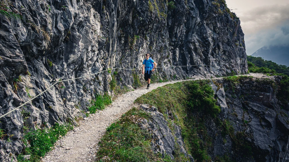 man walking along a cliffside